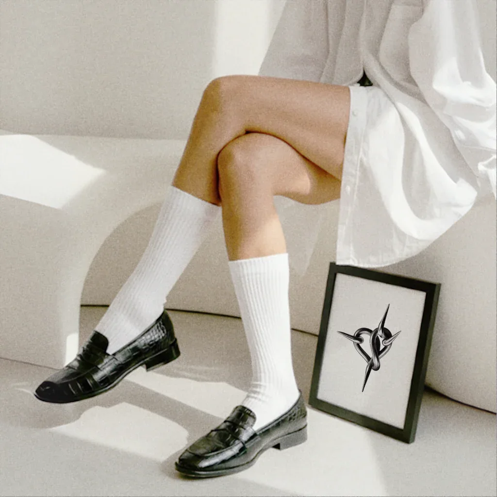 Modischer Poster Herz Ketten Poster in einem modernen Rahmen neben klassischen Schuhen und Socken